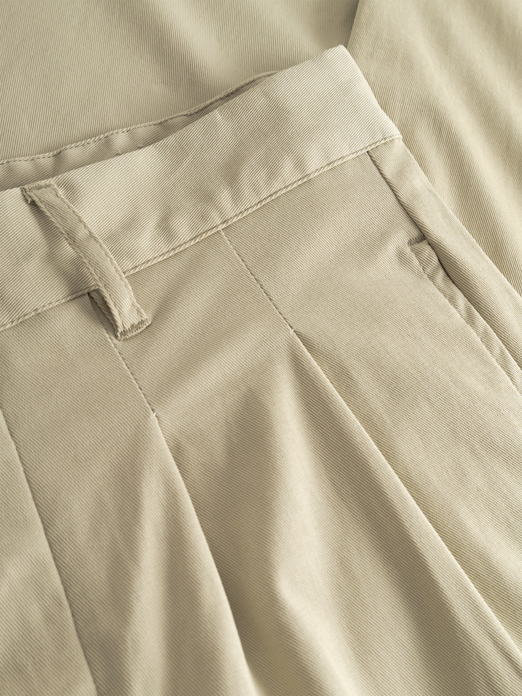 Close-up of Gabba GABfirenze Bolu Cropped TENCEL™ Pant in Alfa Green, highlighting the waistband, belt loop, pleats, and matching fabric. Made from soft TENCEL™ for a relaxed cropped fit.