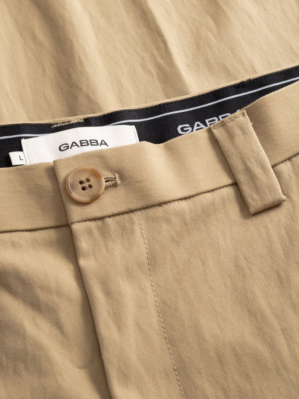 Close-up of Gabba GABdenver Fuggies Pant in Sand, featuring a brown button, belt loops, and visible Gabba waistband labels. The durable, cotton-rich fabric makes these pants ideal for everyday wear.