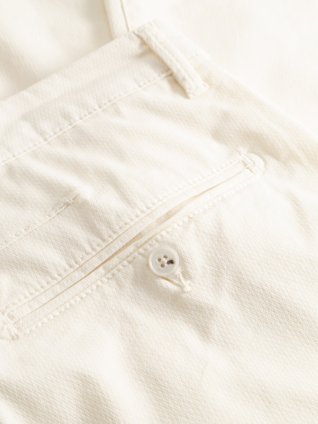 Close-up of the back pocket on Gabba's GABpaul K3280 Dale Chino in white, featuring a button detail, French pockets, and visible stitching.