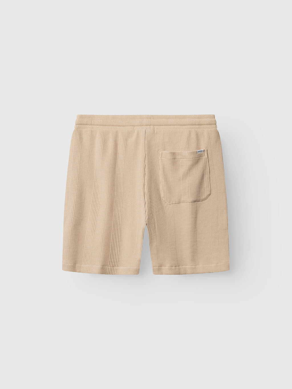 The GABtommi Wup Shorts - Humus by Gabba are beige, ribbed regular-fit shorts with an elastic waistband and a single back patch pocket, crafted from waffle-textured fabric and displayed on a plain light background.