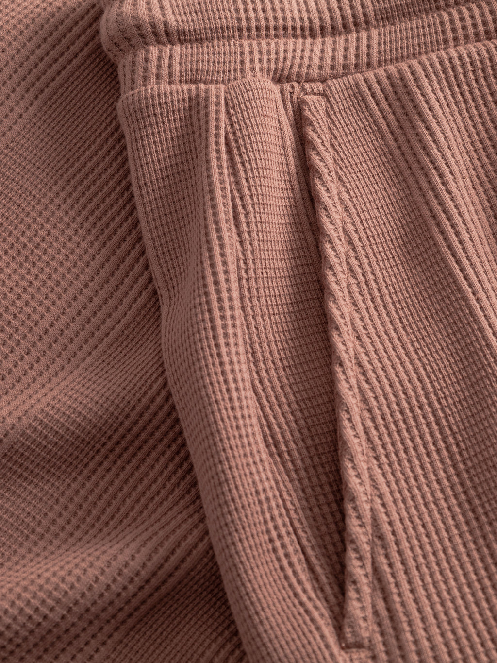 Close-up of Gabba GABtommi Wup Shorts in Wood Pink, showcasing the waffle texture, comfy waistband, seam, and pocket details for a cozy yet stylish vibe.