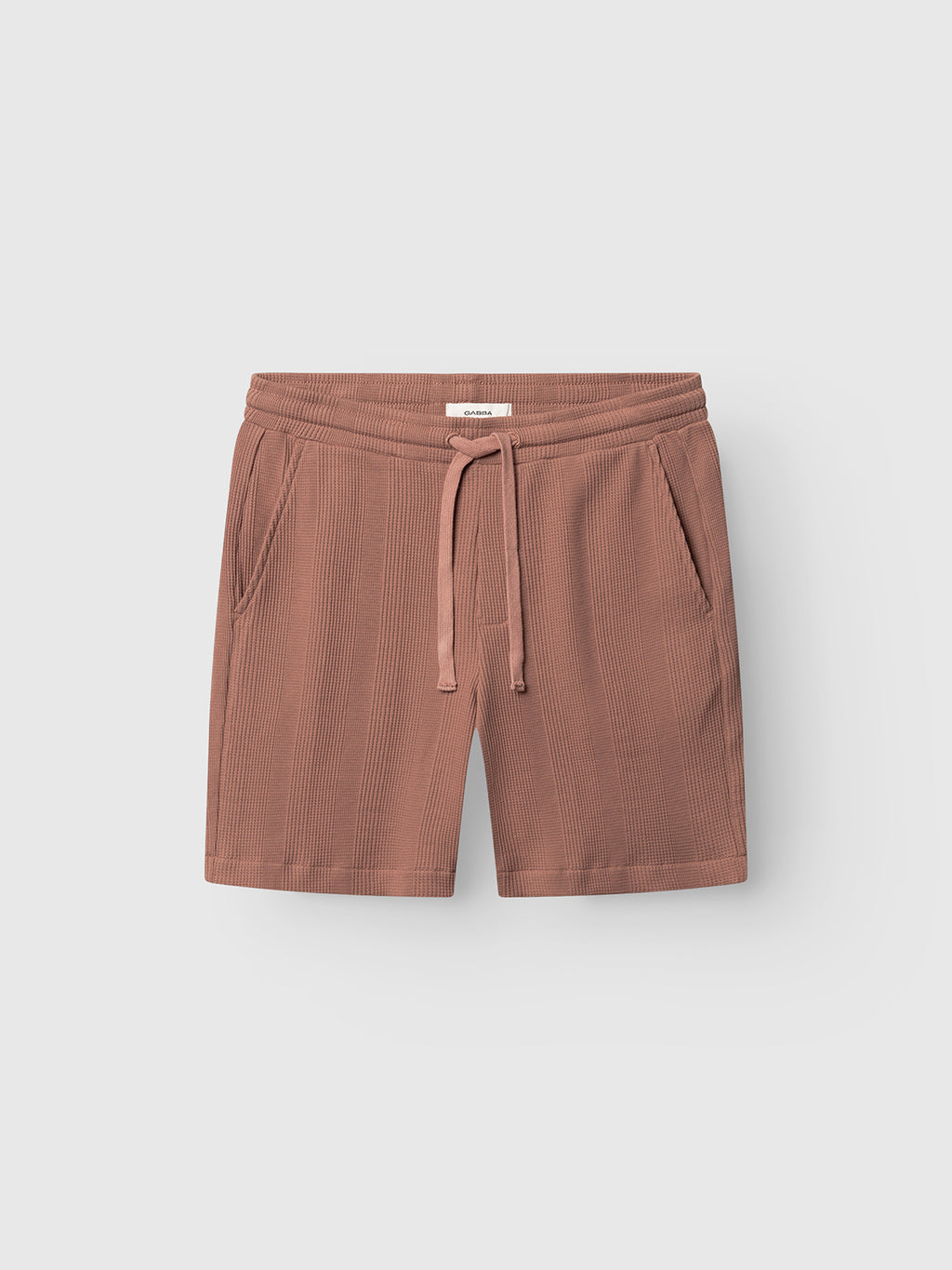 Gabba GABtommi Wup Shorts in Wood Pink, featuring a ribbed waffle texture, comfy elastic waistband with drawstring, and side pockets, displayed flat on a plain light gray background.
