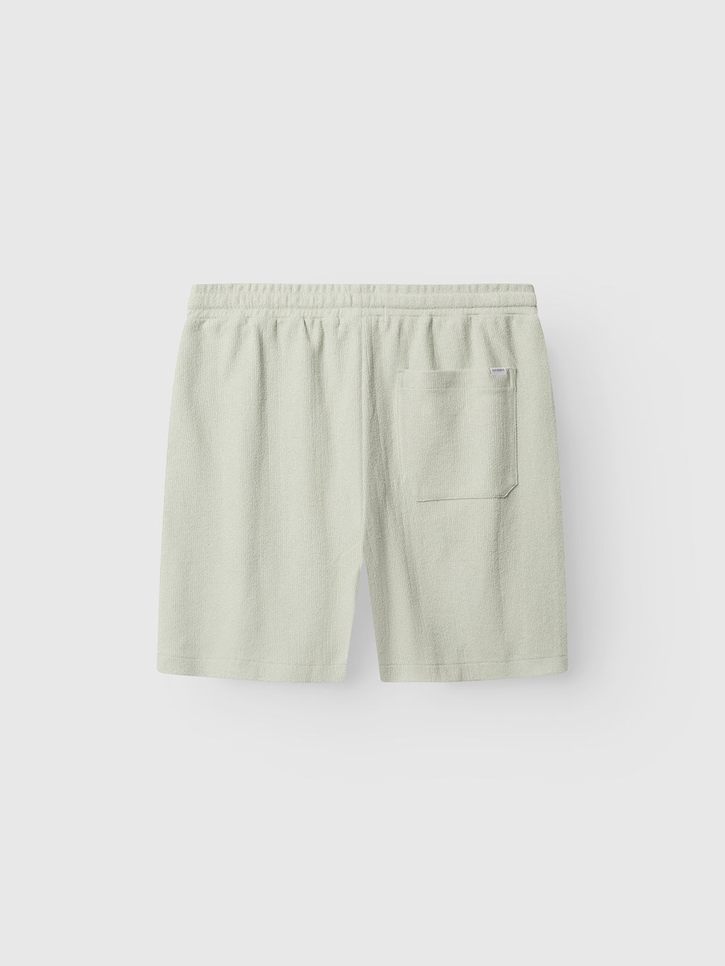 Back view of Gabba GABtommi Towel Shorts in Mineral Gray, featuring an elastic waistband and a single right patch pocket, shown against a plain white background.