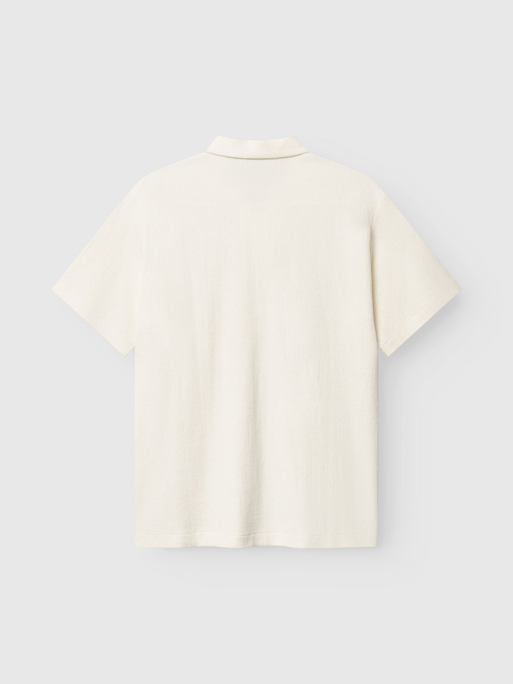 Back view of the Gabba GABlio Sku Towel T-Shirt in Egret, a short-sleeve off-white textured terry cotton blend polo, shown on a plain light gray background.