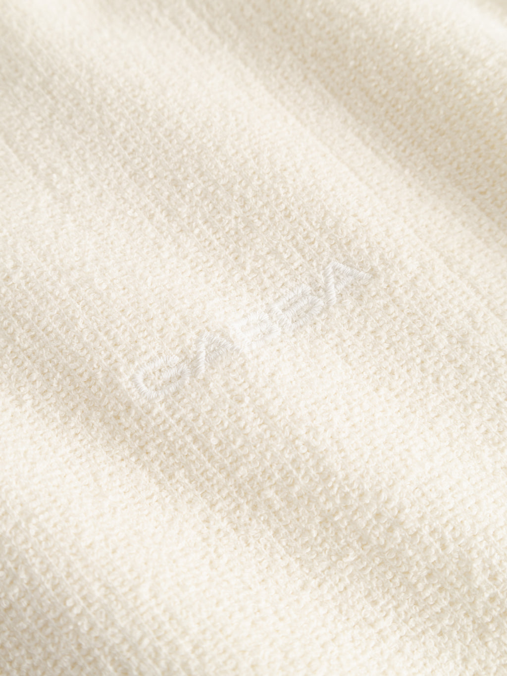 A close-up of the Gabba GABlio Sku Towel T-Shirt in Egret, featuring soft, textured off-white terry cotton with a subtle matching center embroidery.