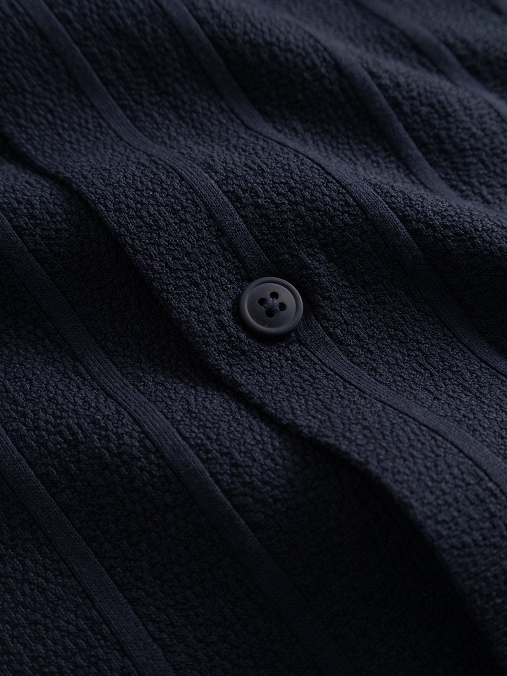Close-up of the Gabba GABvalente Armor SS T-Shirt in navy, featuring textured cotton-blend fabric with vertical ribbed lines and a round black button detail.