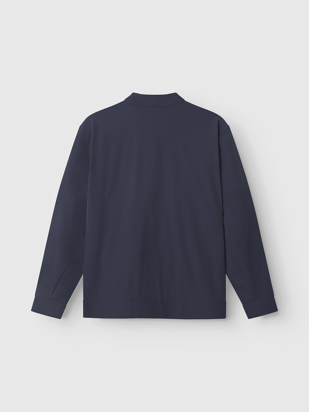 The Gabba GABnik Tech - Navy is a collarless, long-sleeve shirt with straight sleeves and a relaxed fit, displayed from the back on a light grey background for a practical and minimalist look.