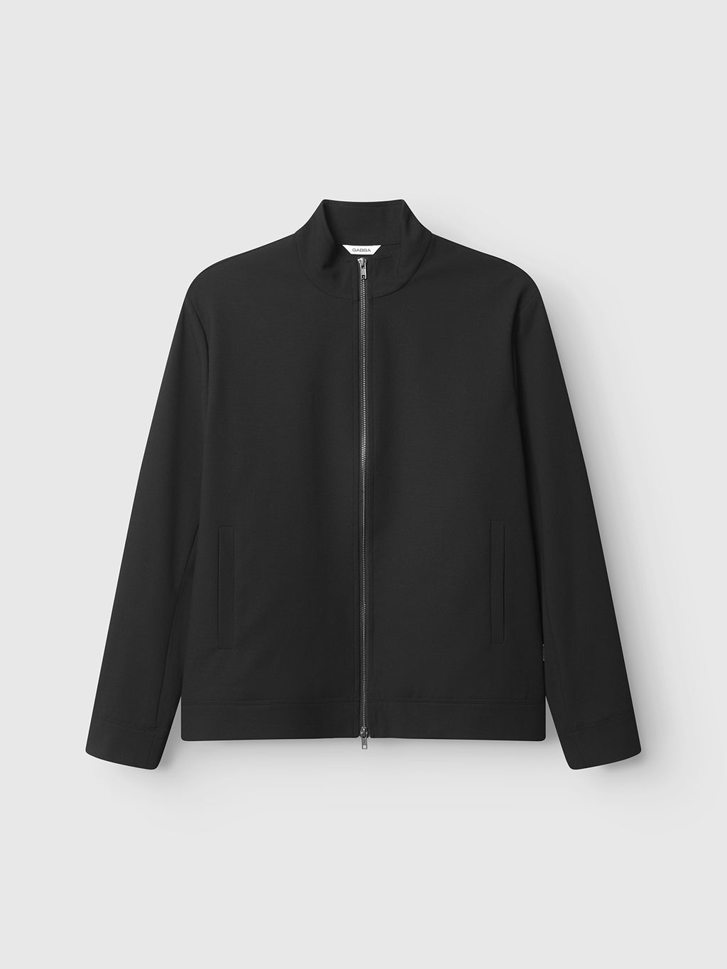 The Gabba GABnik Phin GRS - Black is a minimalist zip-through jacket featuring a high collar, long sleeves, and two front pockets, made from recycled polyester and shown against a plain light gray background.