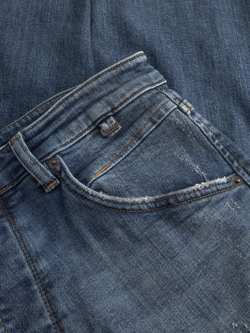 A close-up of the Gabba GABalex Cros Cropped - Mid Blue Denim jeans, featuring the front pocket and waistband with visible stitching and slight fraying, made from recycled cotton.