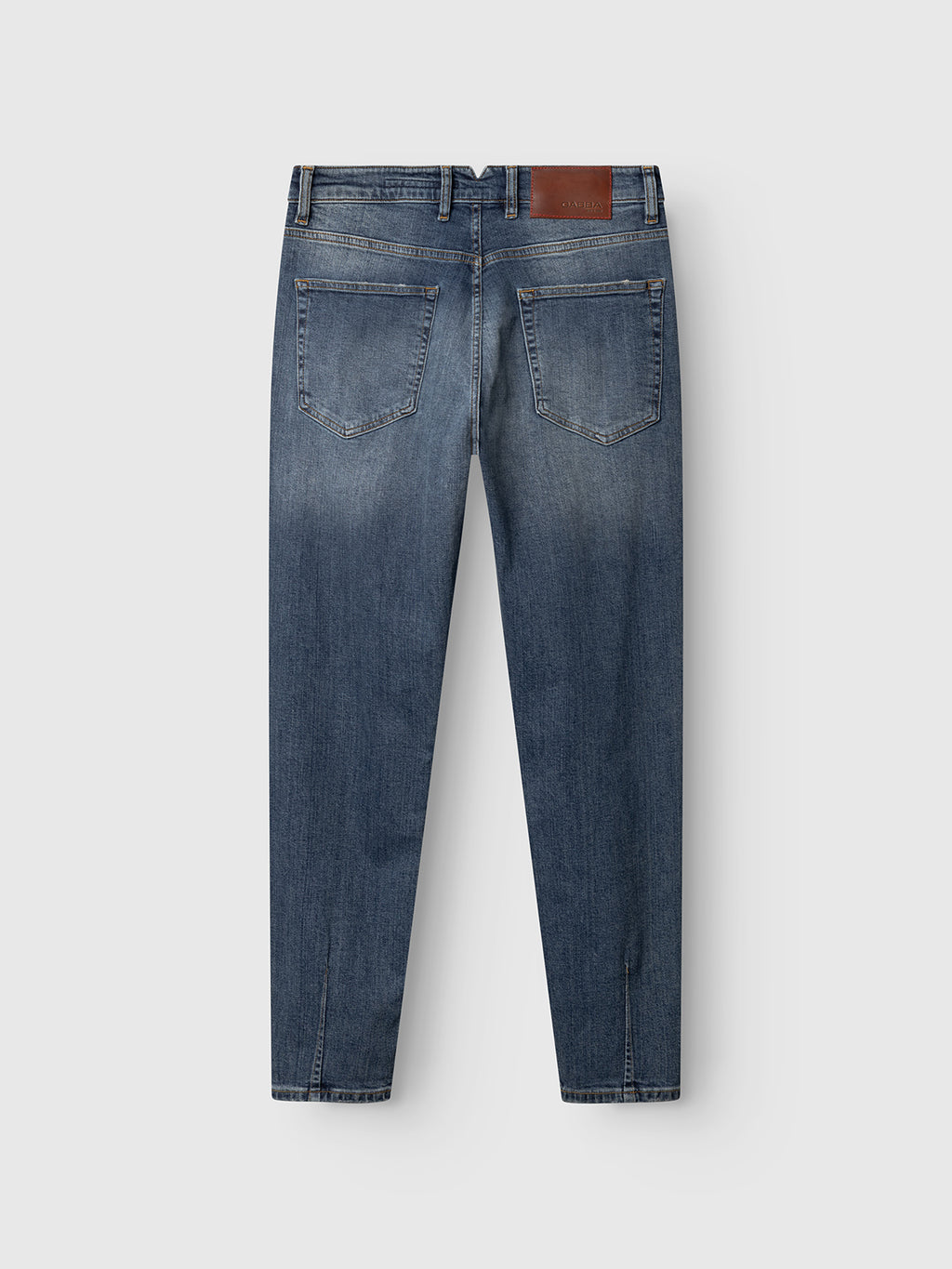 Back view of Gabba GABalex Cros Cropped jeans in mid blue denim, made from recycled cotton with two back pockets, visible stitching, and a brown leather patch on the waistband, shown against a plain light background.