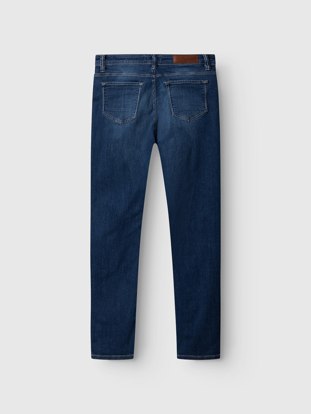 The Gabba GABjones K3870 Mid Blue Denim slim jeans, shown from the back with two rear pockets, belt loops, and a brown leather patch on the waistband, are made from super-stretch fabric and displayed flat on a light grey background.