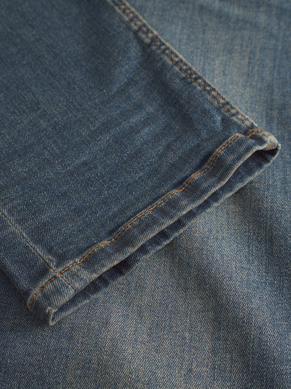 Close-up of the hem on GABBA GABrey K3606 Mid Blue Jeans, showcasing the mid blue denim fabric texture, stitching, and seam details against a laid-back denim background.