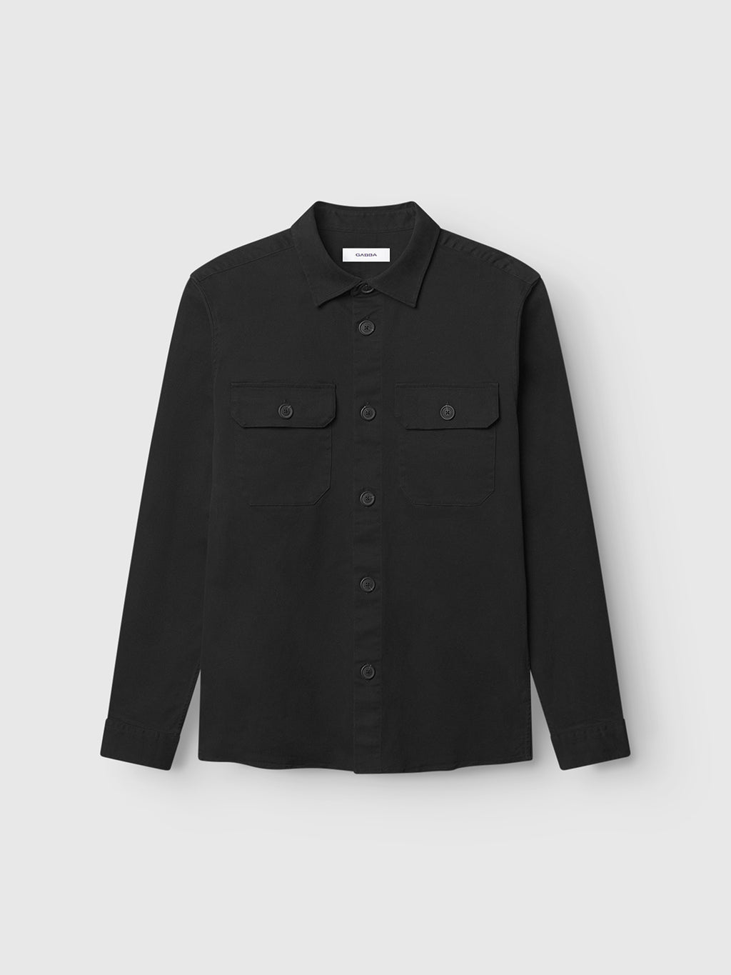 The GABBA GABtopper LS Shirt in black features a shirt collar, long sleeves, and two button-flap chest pockets, shown against a plain light gray background.