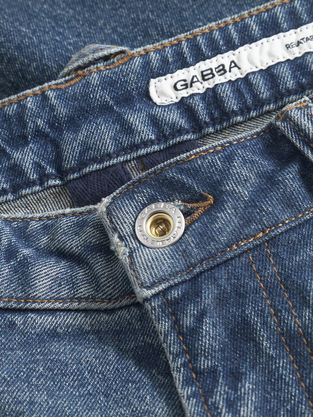 Close-up of GABcarl OskinV2 Jeans in dark blue denim, featuring a metallic button and a white Gabba label stitched on the waistband. Detailed stitching and textured denim highlight these casual jeans.