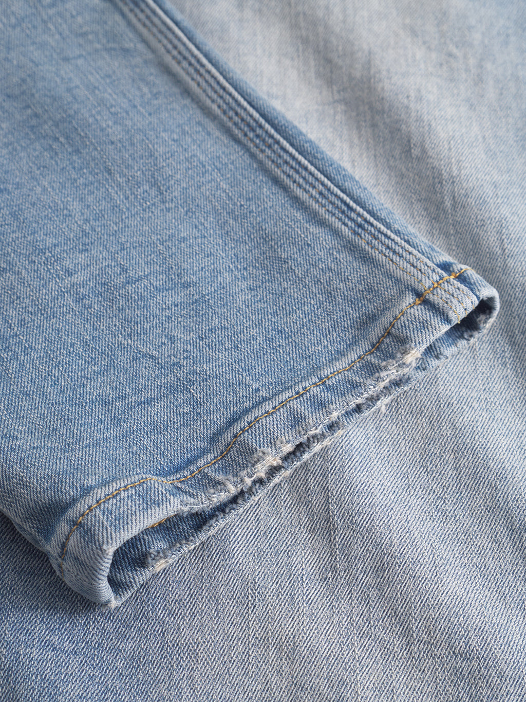 Close-up of Gabba GABcarl CrosV2 Jeans in light blue denim, featuring a frayed hem and visible stitching, laid flat on matching denim for a stylish, modern look.