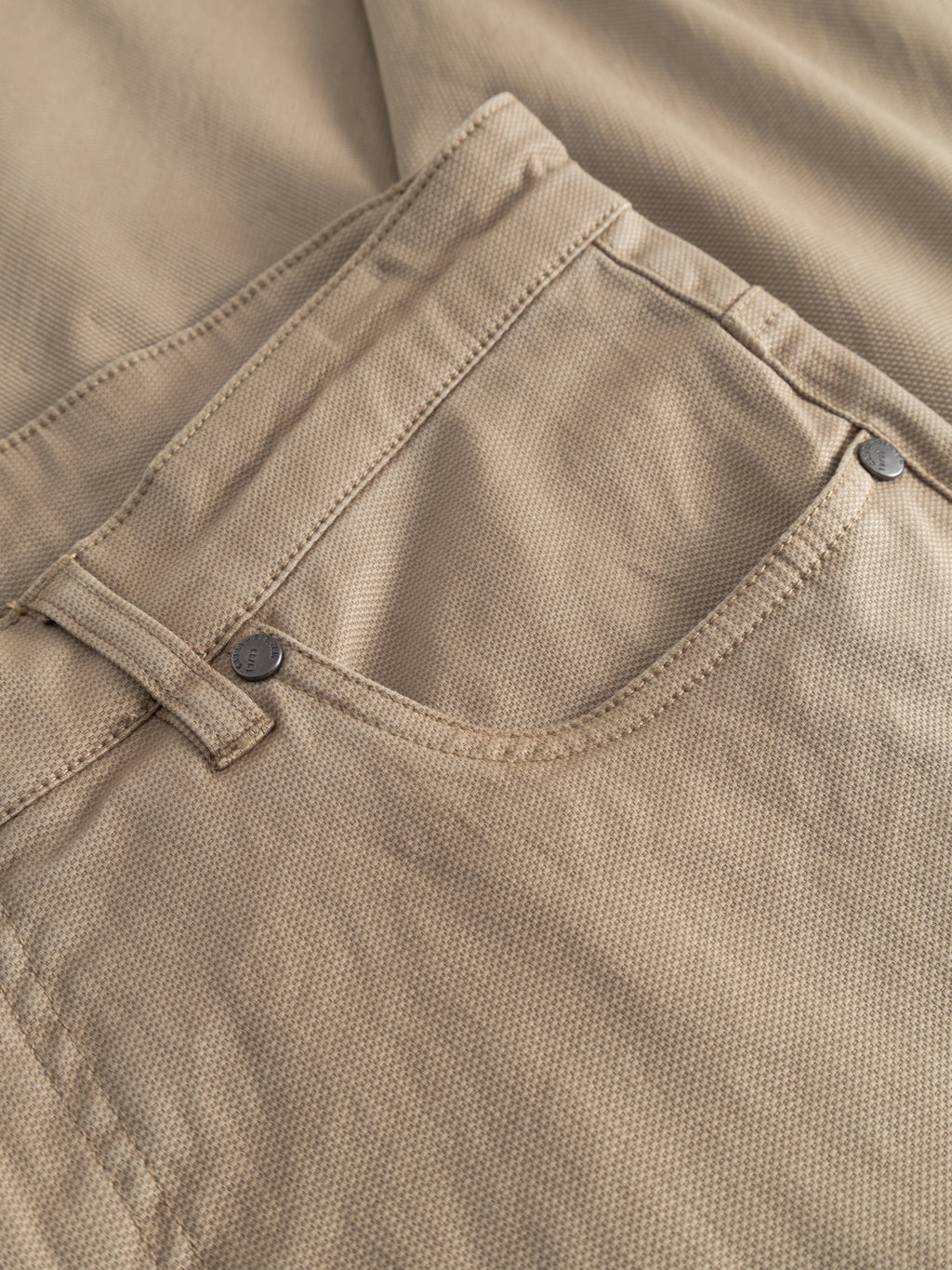 Close-up of the front pocket area on Gabba GABmarc 5poc Marlo - Coriander jeans, highlighting textured beige fabric, a belt loop, visible stitching, and metal rivets at the corners.