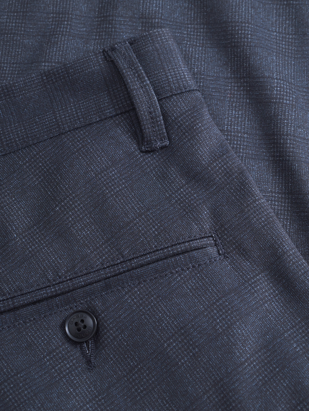 Close-up of Gabba’s GABpaul Nygo - Navy trousers featuring a dark navy plaid pattern in a versatile slim chino design. The image highlights the subtle checkered texture, belt loops, waistband seam, and back pocket finished with a black button. Crafted from comfort stretch fabric, these trousers offer both refined style and ease of movement, with the fabric texture clearly visible for added detail.
