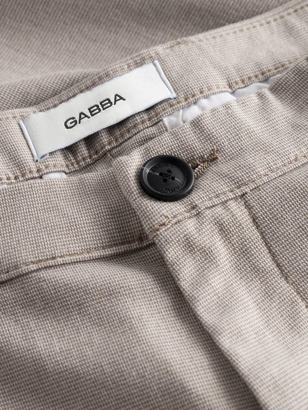 Close-up of Gabba’s Pisa Domo Pants in Coriander, featuring a black button, belt loop, and white GABBA label—designed for lasting style and everyday durability.