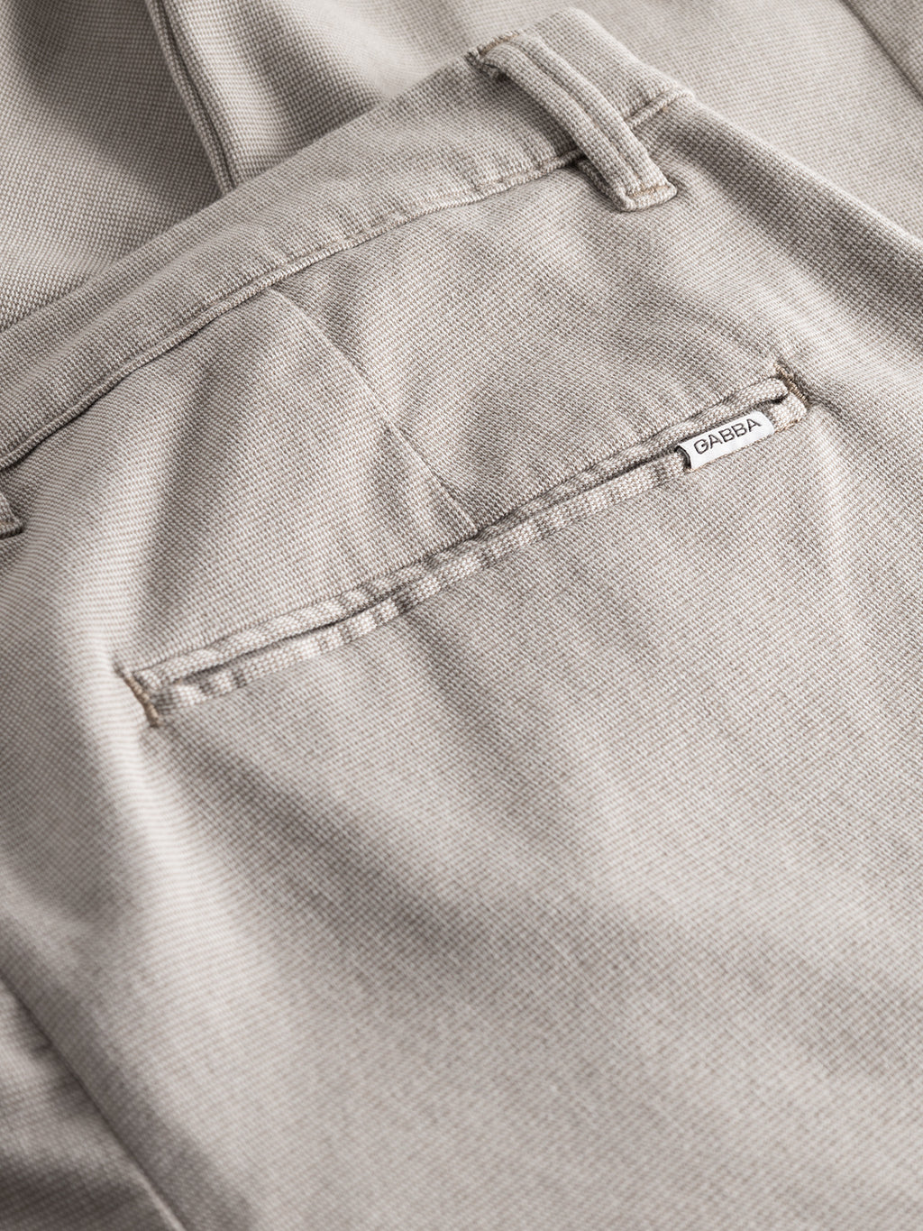 Close-up of the back pocket of Gabba Pisa Domo Pants in Coriander, featuring a small white GARDA label above the pocket. The textured fabric and minimalist design reflect Gabba’s commitment to quality and timeless style.