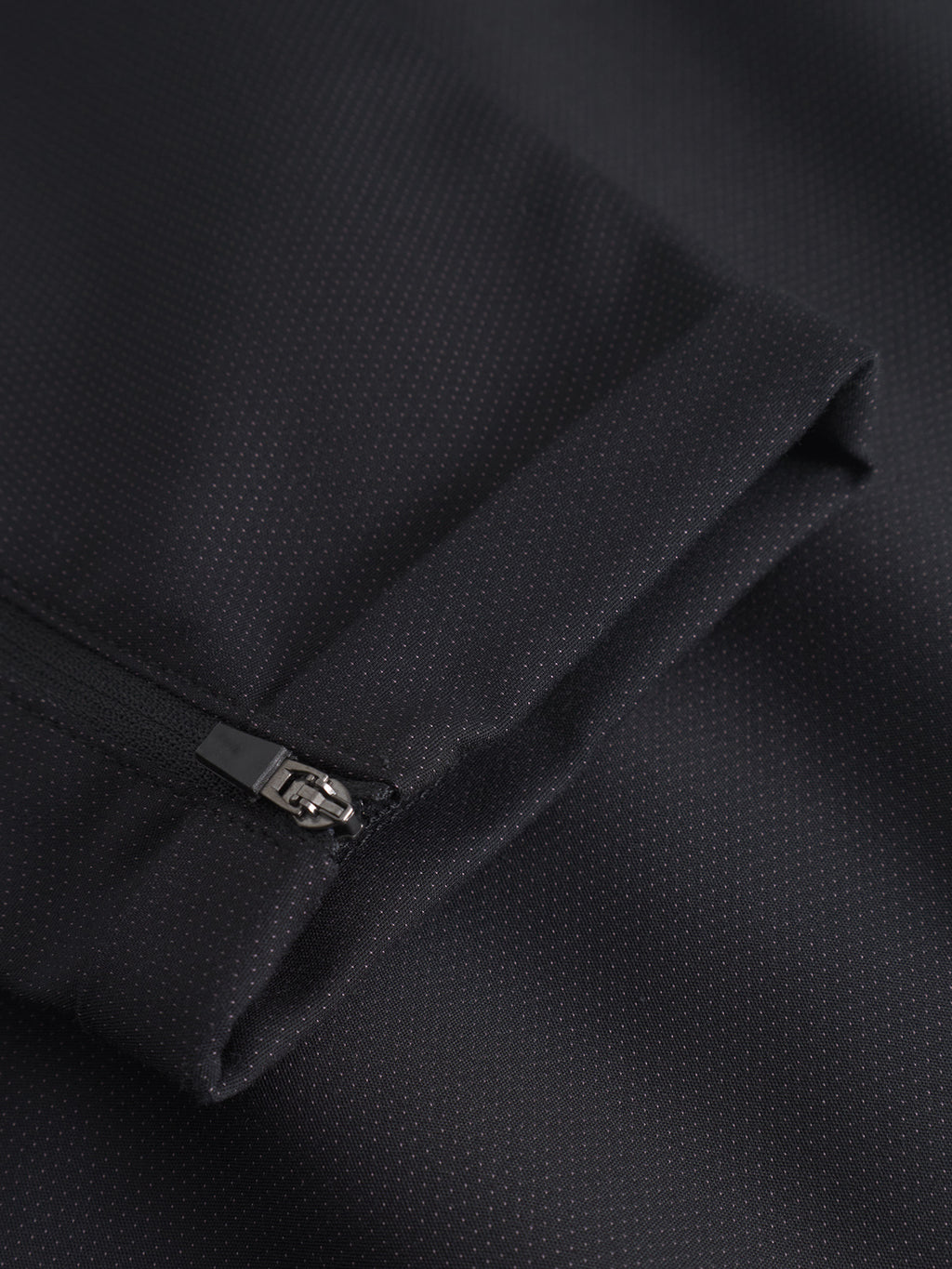Close-up of GABBA's Pisa Small Dot - Black pants, featuring high-stretch cotton-blend fabric with a subtle dot pattern and a partially unzipped zipper—ideal for refined metro style.