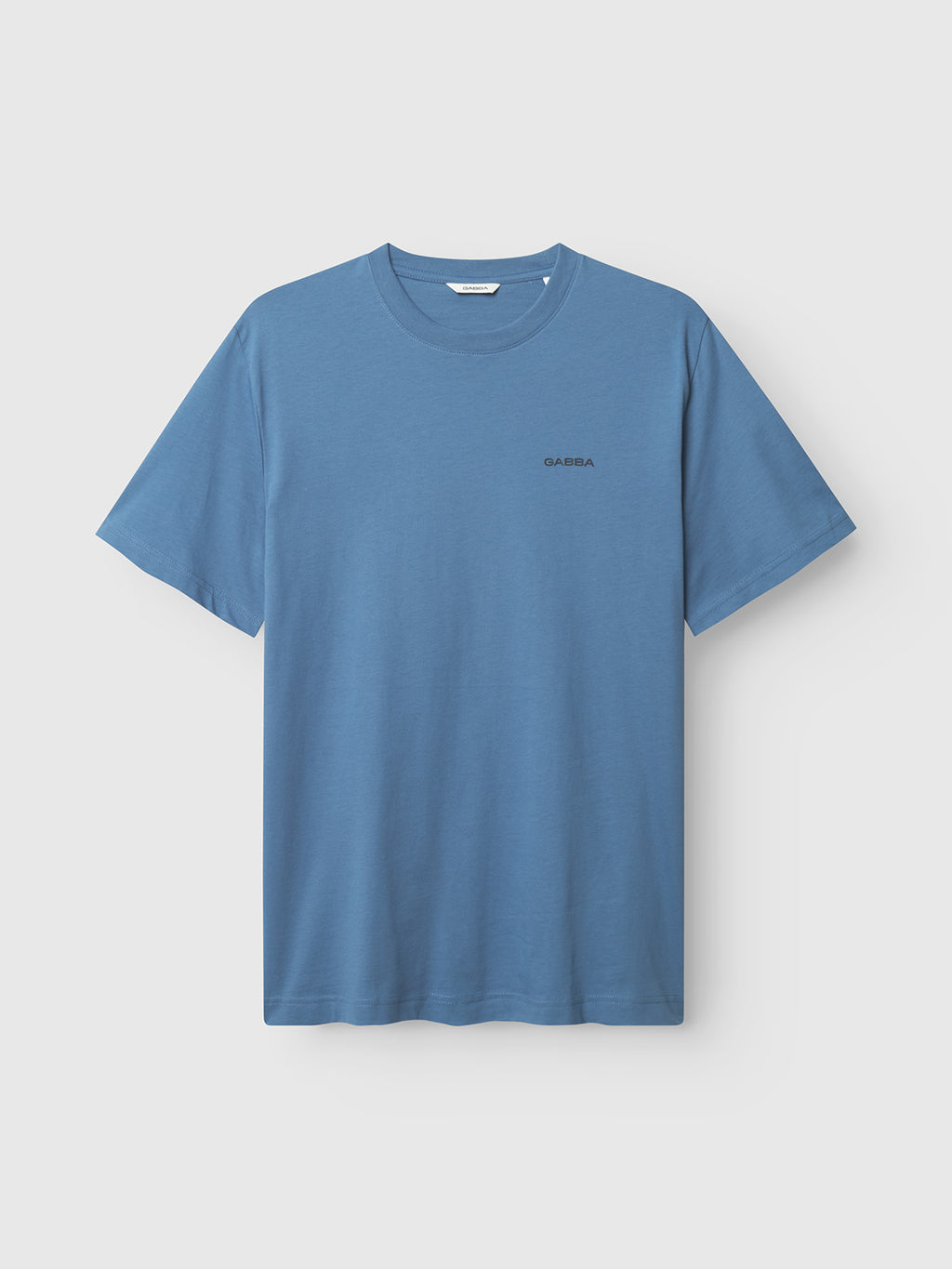 The Gabba GABdune Logo GOTS SS T-Shirt in Blue Horizon is a classic fit, plain blue organic cotton tee with a small logo on the left chest, shown against a light gray background.
