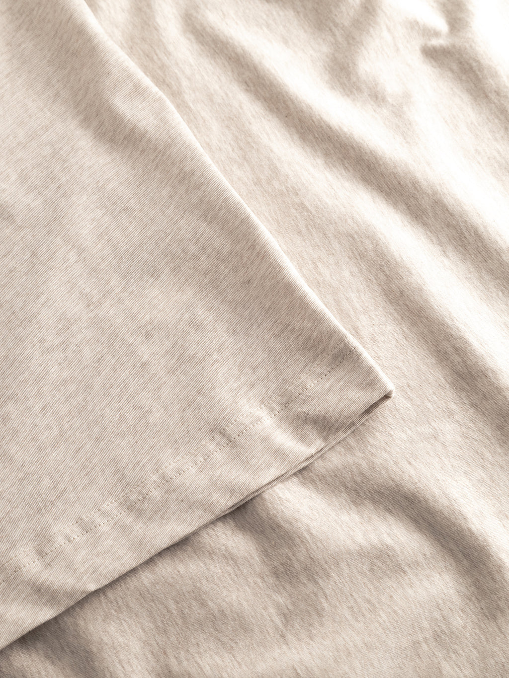 Close-up of the Gabba GABdune Melange New SS T-Shirt in Sand Mel., highlighting the stitched hem and soft, slightly wrinkled cotton jersey fabric.