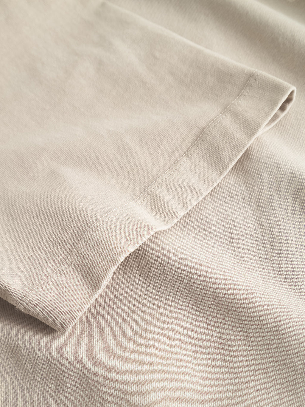 Close-up of the hem and sleeve on the Gabba GABnigel Wix Boxy Hour SS in Sand Cashmere, showcasing the heavyweight cotton texture and detailed stitching.