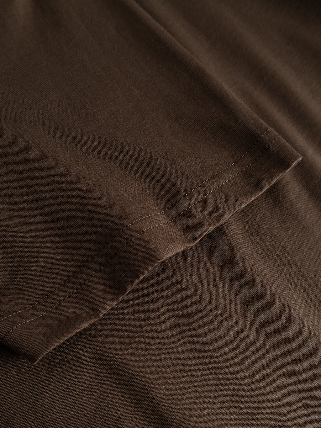 Close-up of the hem and stitching on the Gabba GABdune Logo GOTS SS T-Shirt in Brown Slate, highlighting the texture and detail of the material.