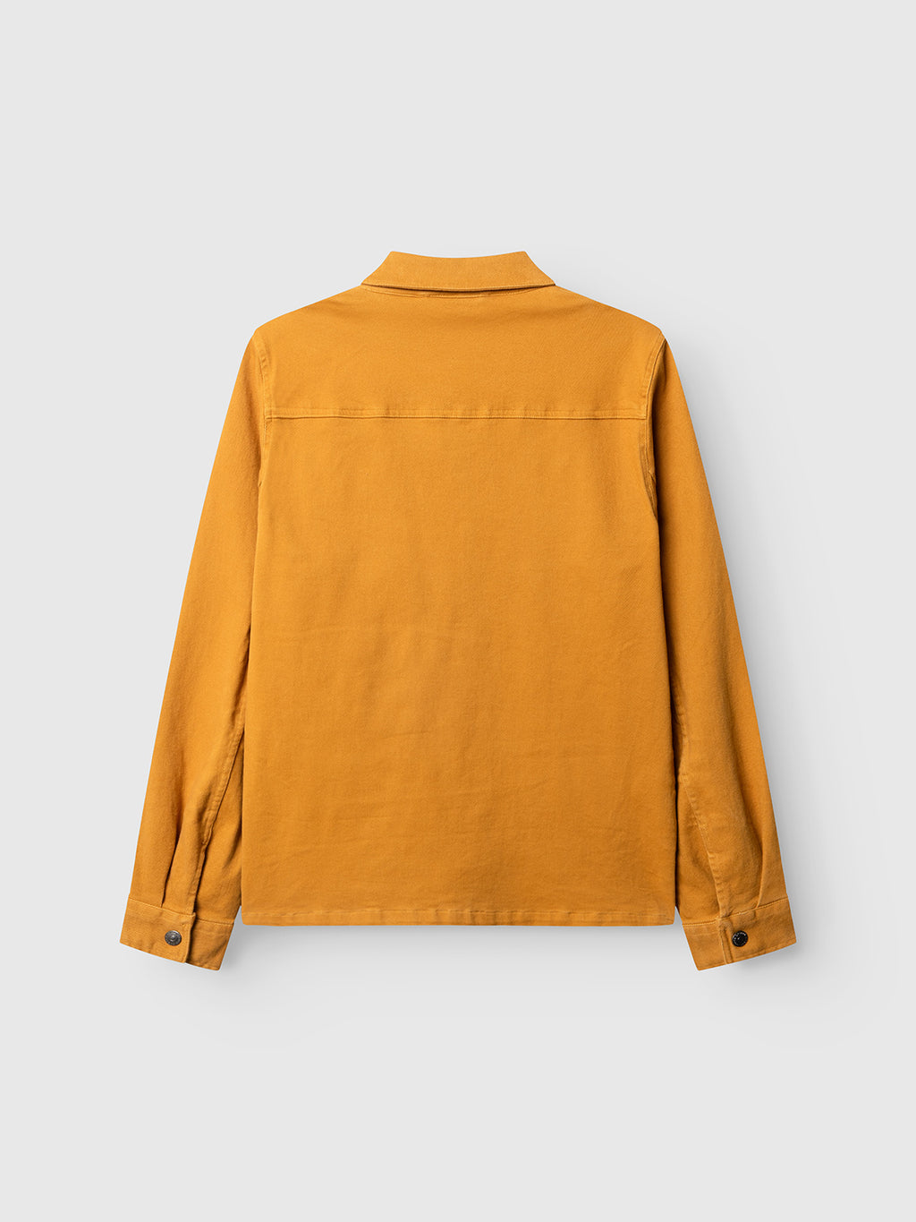 A back view of the Gabba GABbeta Twill shirt in mustard yellow, featuring a collar and buttoned cuffs, crafted from garment-dyed stretch twill and laid flat against a light gray background.
