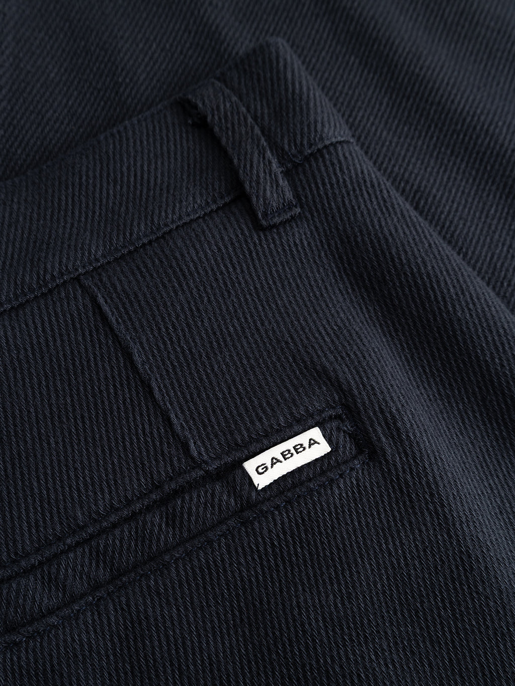 Close-up of the GABJoe-Pas Vill - Blue Black trousers by Gabba, featuring a dark, textured utility-inspired design with a visible back pocket and a white Gabba tag sewn near the pocket seam.