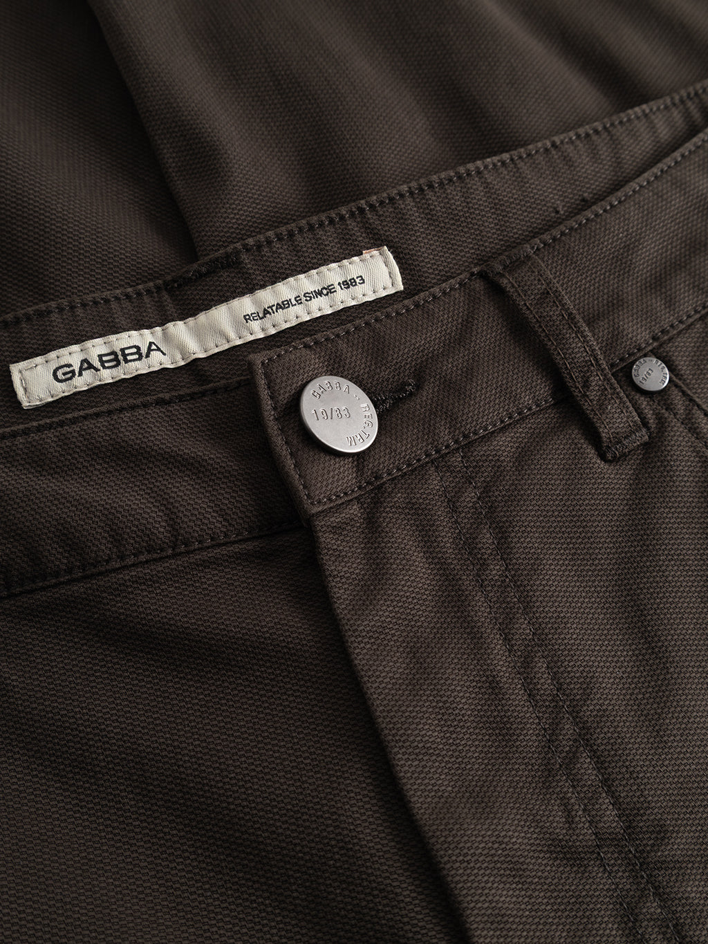 Close-up of the Gabba GABmarc 5poc Marlo pants in Brown Slate, designed for everyday wear, featuring a metal button, belt loops, detailed stitching, and a white Gabba brand label sewn inside the waistband.