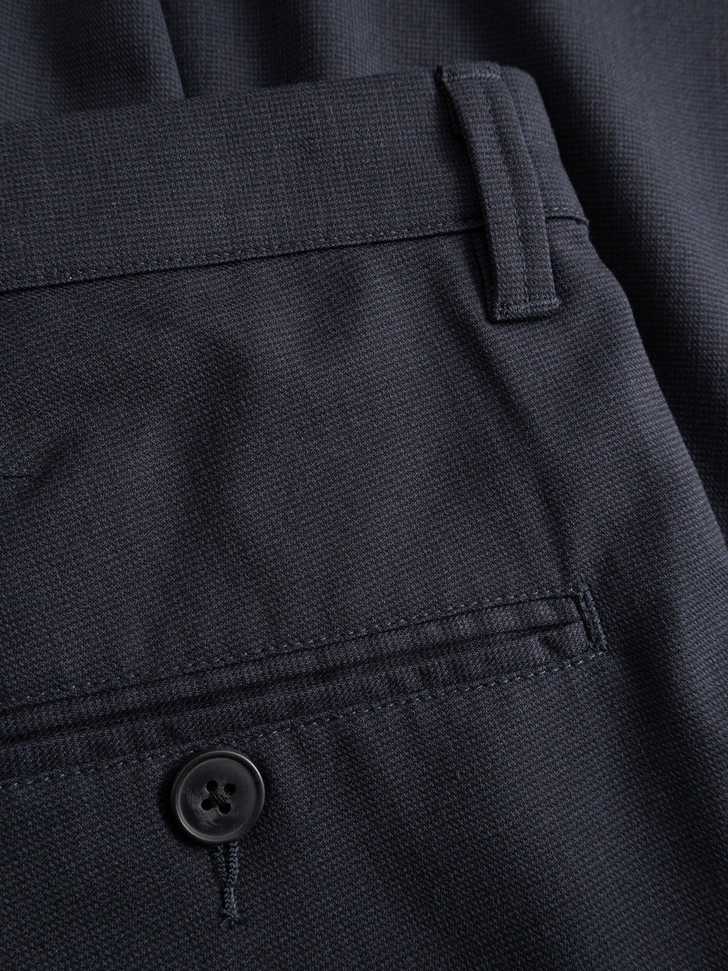 Close-up of the Gabba GABpaul Deme Pant in Dark Navy, showcasing a slim chino fit with a waistband and belt loops, buttoned back pocket, and micro-pattern woven fabric—perfect for everyday wear.