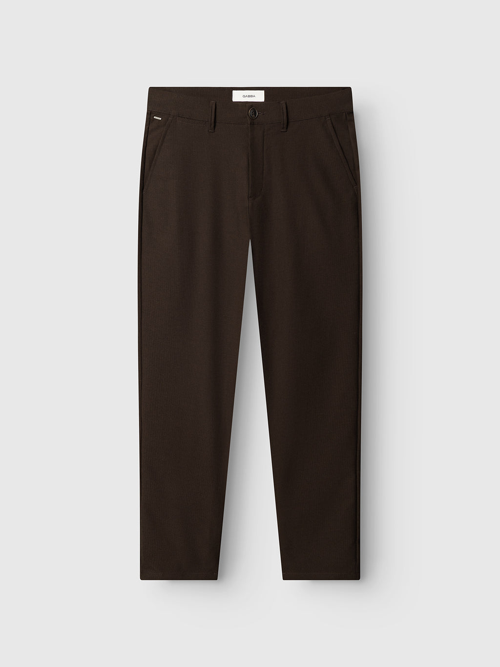 The GABpaul Deme Pant - Brown Slate by Gabba is a pair of dark brown straight-leg trousers, crafted from versatile chino micro-pattern woven fabric, featuring side pockets, belt loops, and a button closure, displayed flat against a white background.