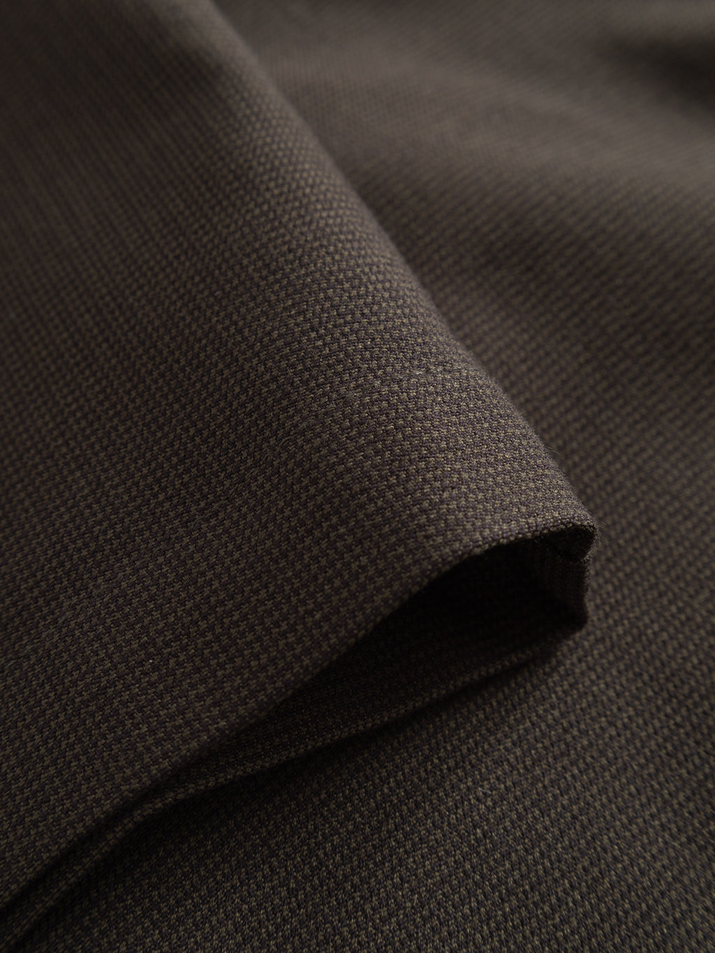 A close-up of the GABpaul Deme Pant in Forest Night by Gabba reveals its finely woven micro-pattern and soft texture—ideal for crafting a versatile chino with a slim fit.