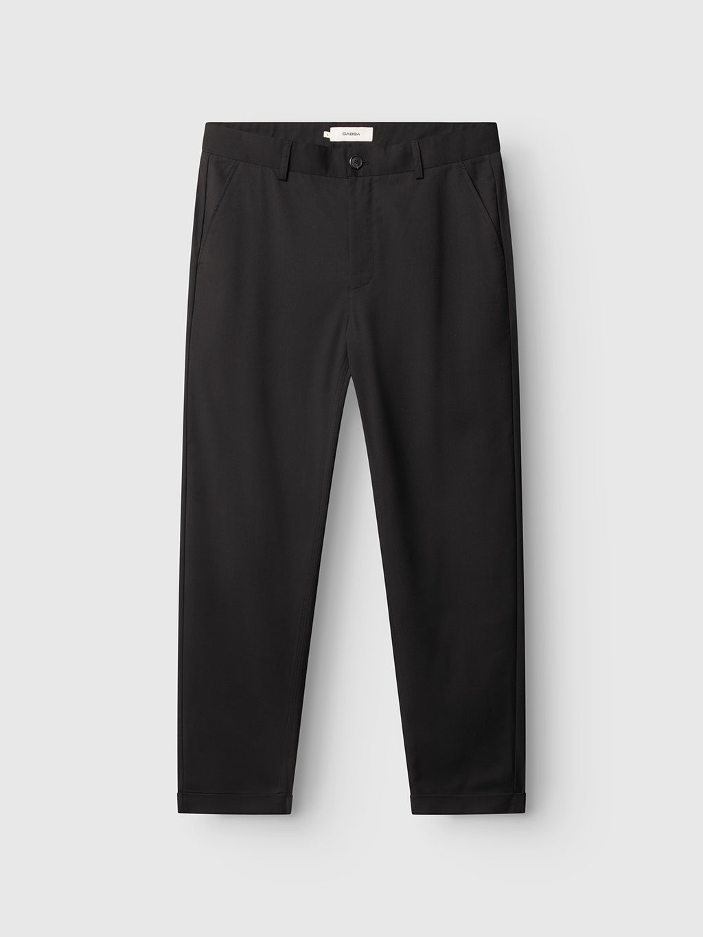 The Gabba GABjoe Turnup Fin Pant in black is a tapered-fit chino made from a twill viscose blend, with side pockets and a button closure, shown laid flat on a light gray background.