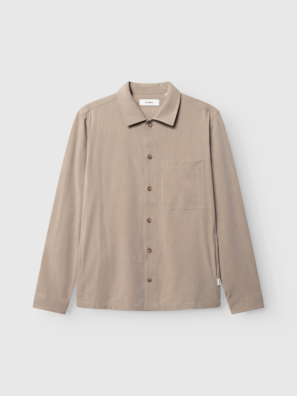 The GABtogger Tailor Dressy Overshirt - Sand by Gabba is a long-sleeved, sand-colored wool-blend overshirt featuring a collar and a single chest pocket, crafted from soft melange fabric and shown on a plain white background.