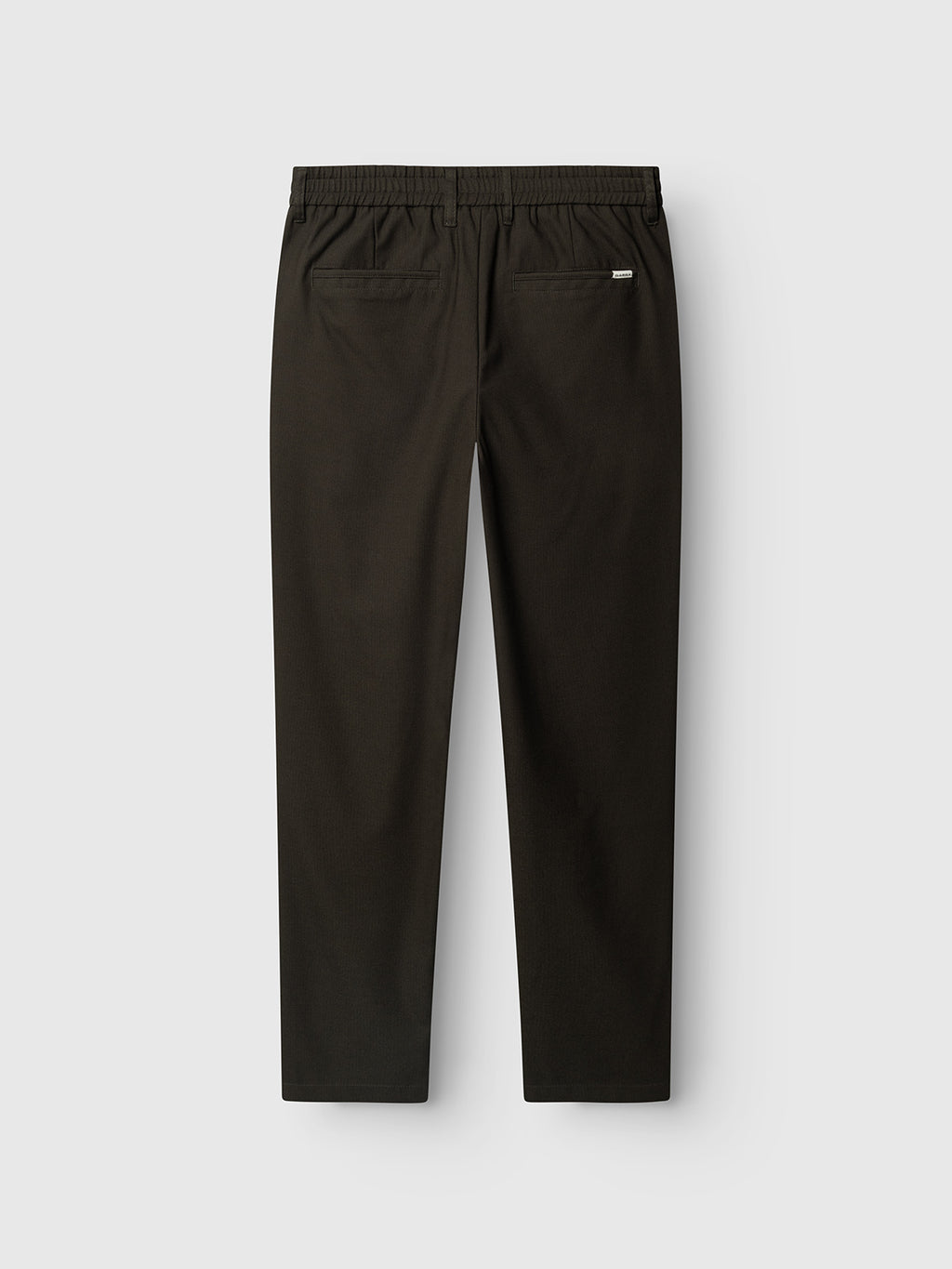 Back view of the Gabba GABmonza Tasca Deme Pant in Forest Night, featuring an elastic waistband and two back pockets—one accented with a small rectangular label. Crafted from micro-patterned fabric in a relaxed straight fit, these trousers are laid flat on a light gray background.
