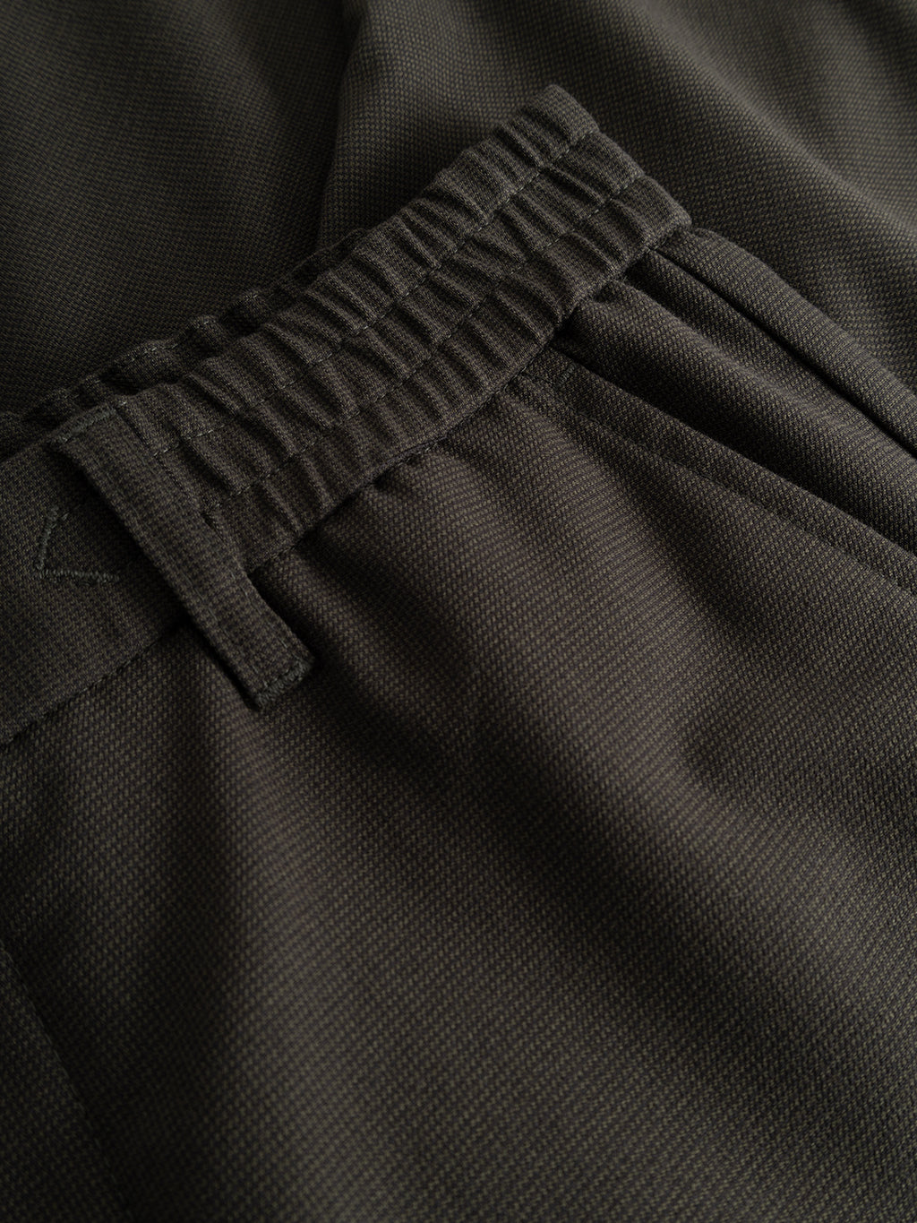 Close-up of the Gabba GABmonza Tasca Deme Pant in Forest Night, featuring an elastic waistband and side pocket, highlighting the relaxed straight fit and textured micro-patterned fabric with fine stitching details.