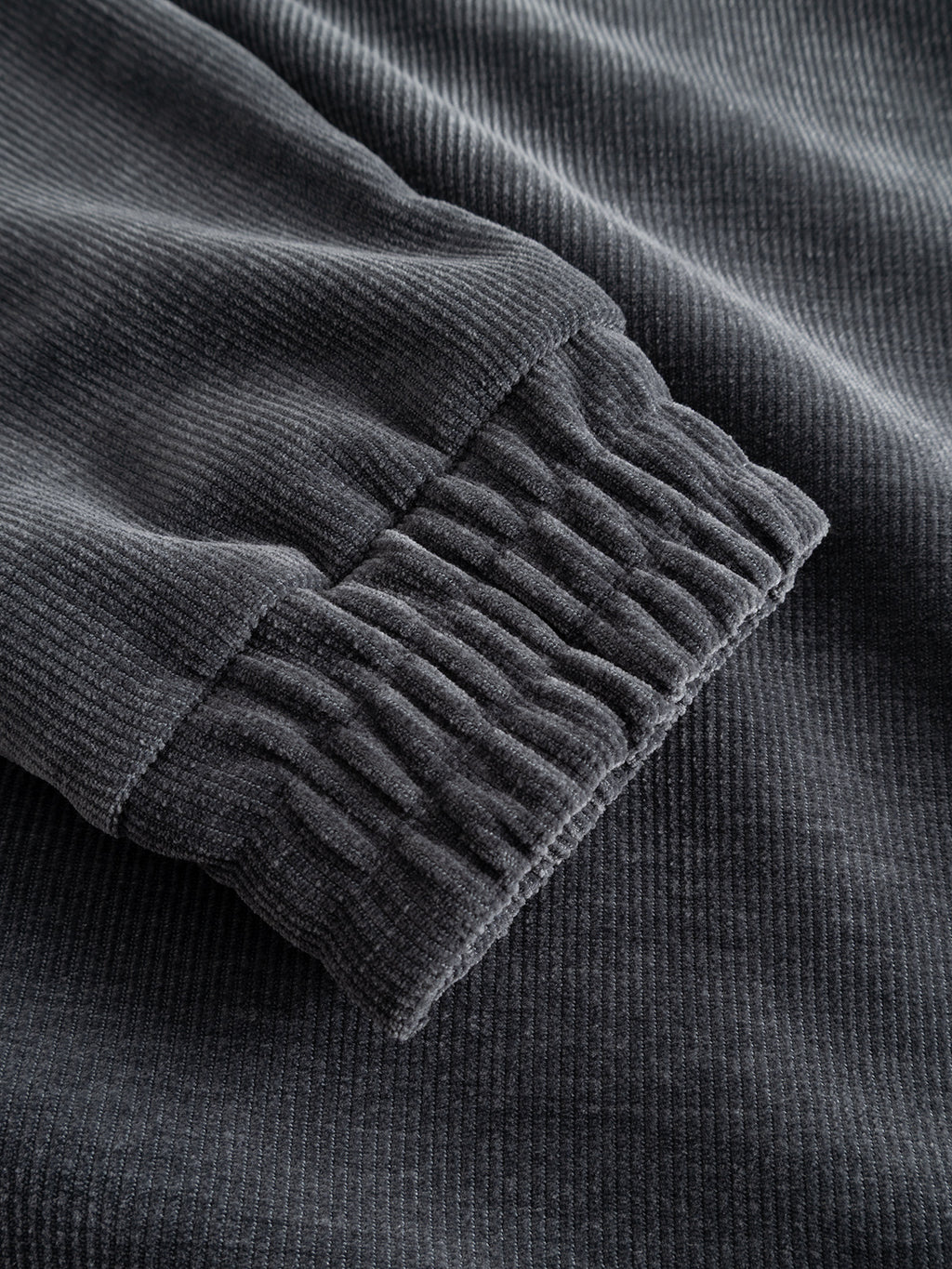 Close-up of the GABnik Pulz Fune Jacket by Gabba in Turbulence Blue, featuring a dark gray corduroy fabric sleeve with a gathered elastic cuff that highlights the ribbed texture—an elevated detail typical of modern outerwear.