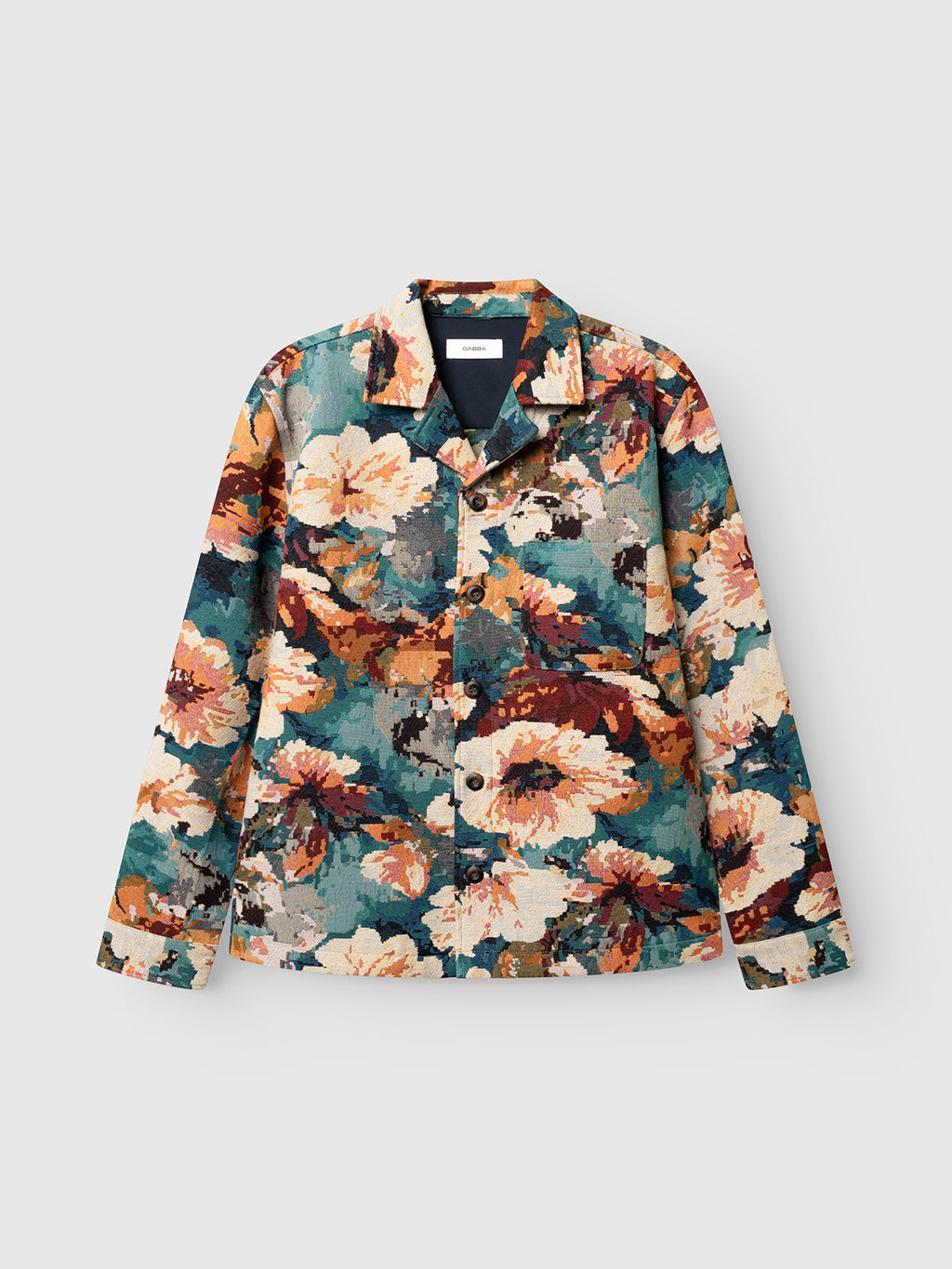The GABsimone Reso Fiore LS Overshirt by Gabba features a relaxed fit and long sleeves, showcasing a bold multi-pattern in teal, orange, beige, and brown tones. Crafted from viscose-blend jacquard fabric with a button-up front and resort collar, this statement piece is displayed against a plain light background.