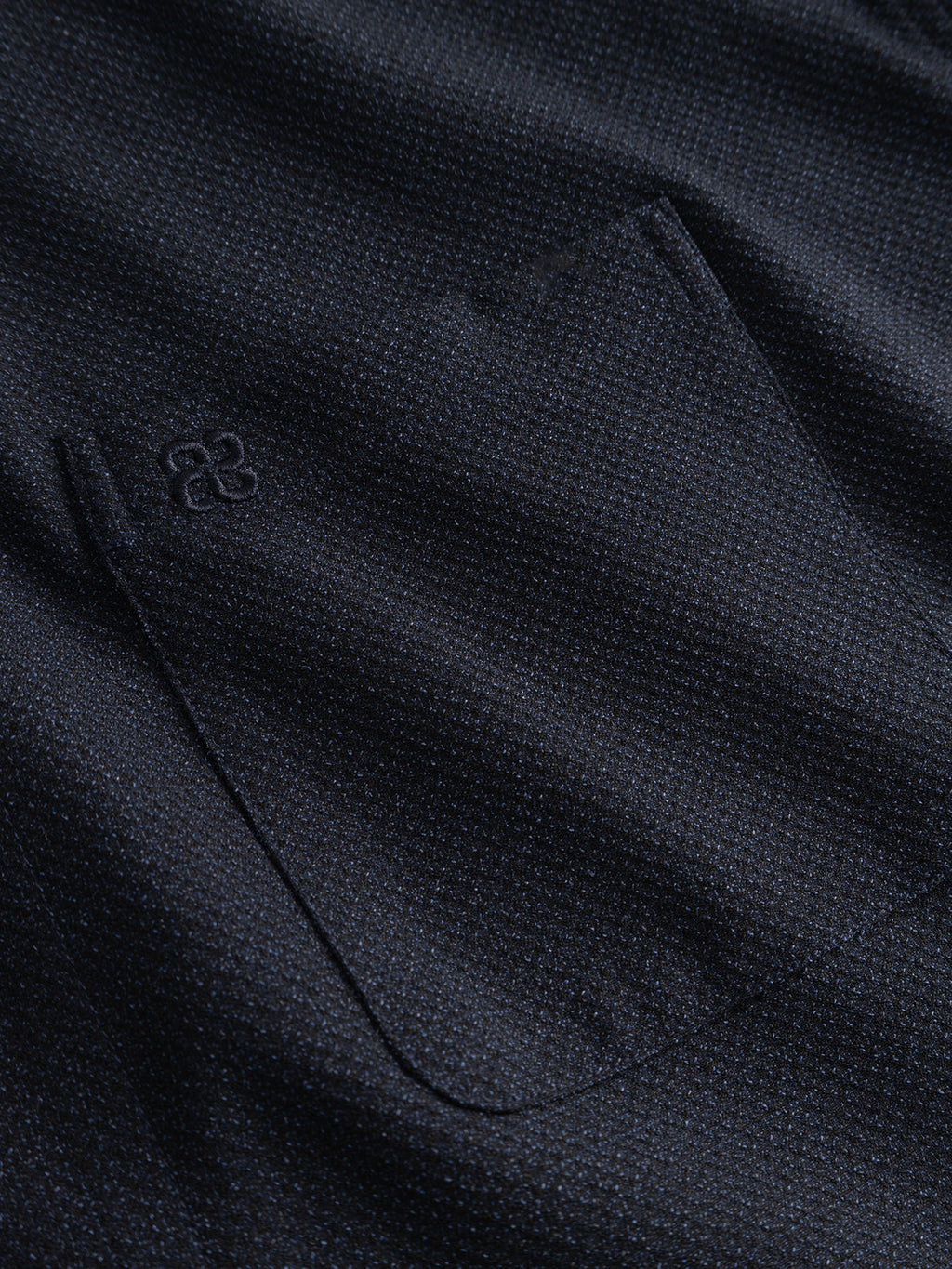Close-up of the Gabba GABjens Over Rubin LS Overshirt in Blue Black, featuring dark blue stretch dobby fabric with a pocket and a small embroidered logo above it, highlighting the overshirt’s distinctive textured design.