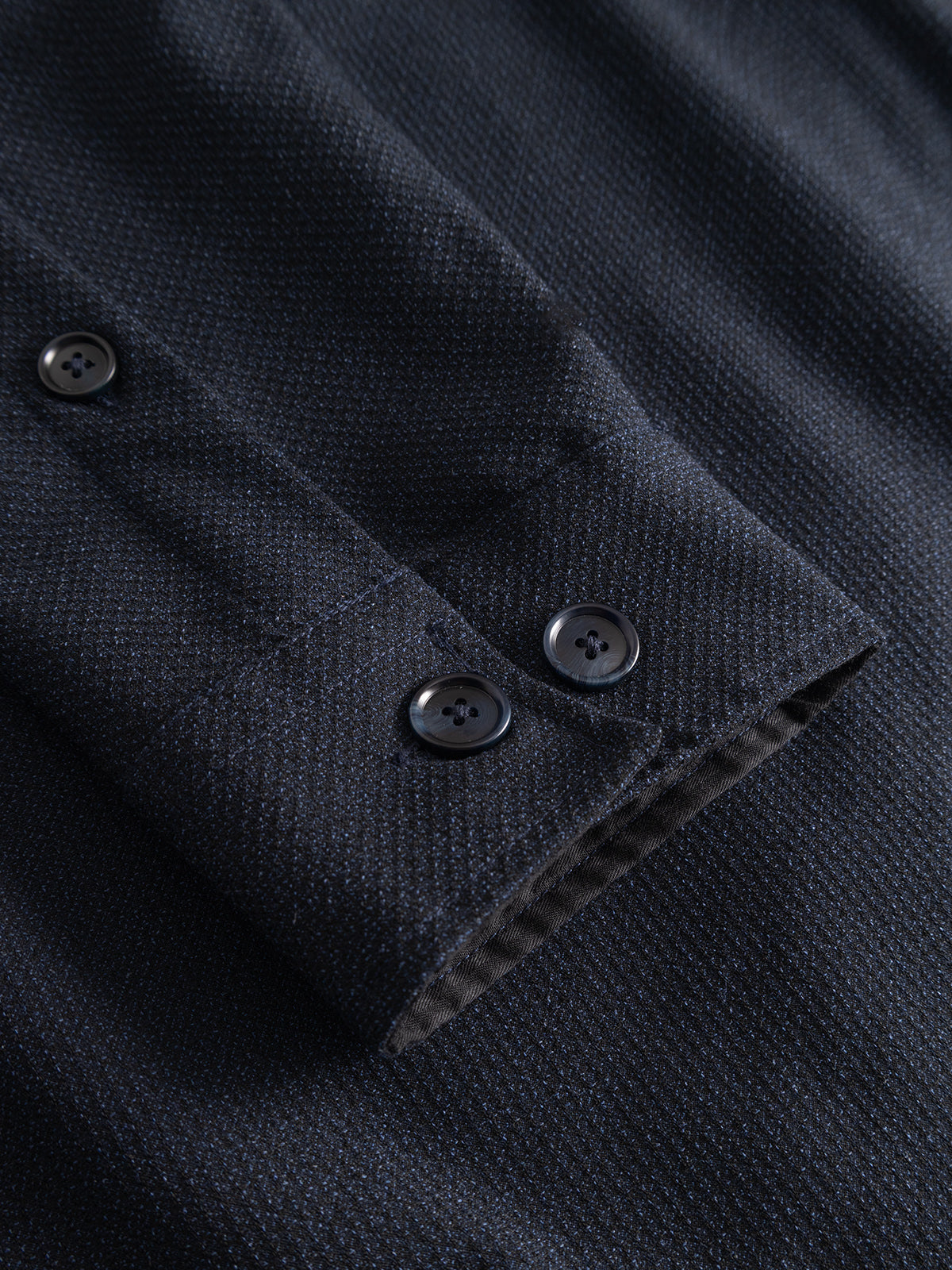 Close-up of the Gabba GABjens Over Rubin LS Overshirt in Blue Black, showcasing the dark navy blue cuff with a subtle textured pattern. Crafted from stretch dobby fabric, it features two black buttons for fastening. The soft, slightly reflective material enhances comfort and flexibility, making it ideal for an oversized fit.