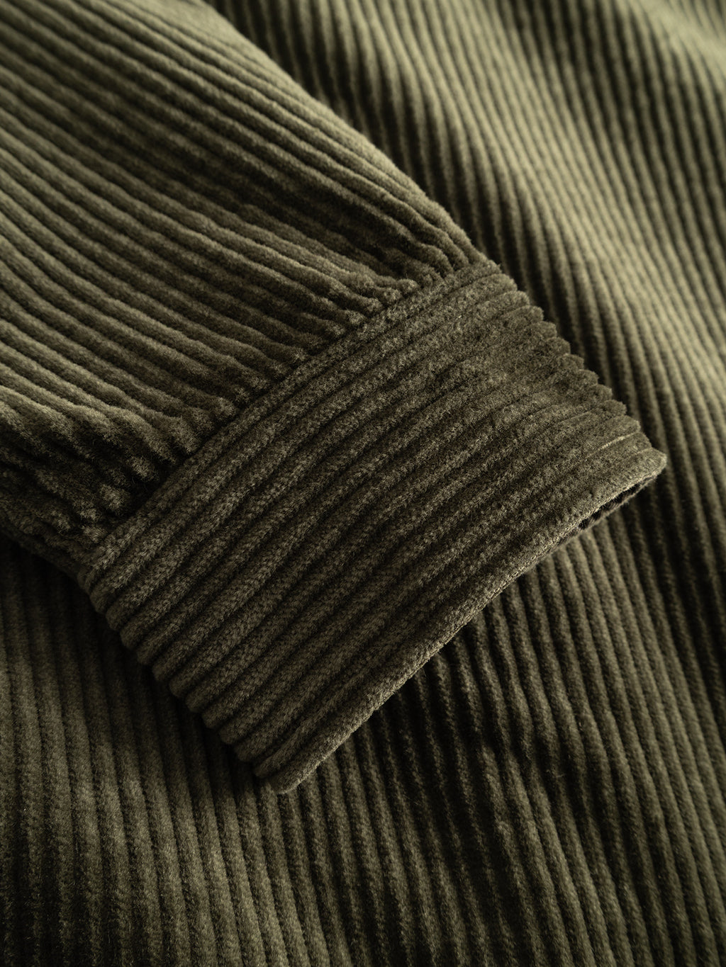 Close-up of the GABbeta Ibre LS Overshirt in Forest Night by Gabba, highlighting the detailed vertical ridges and soft texture of its brown stretch corduroy fabric sleeve—an ideal layering essential for versatile styling.
