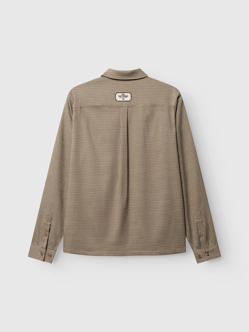 The Gabba GABfelix Brit LS Shirt in Dark Sand, a relaxed fit, long-sleeve collared shirt, is shown from the back against a plain white background. Crafted from lightweight woven fabric with a subtle micro-check pattern, the design features a rectangular patch near the collar.