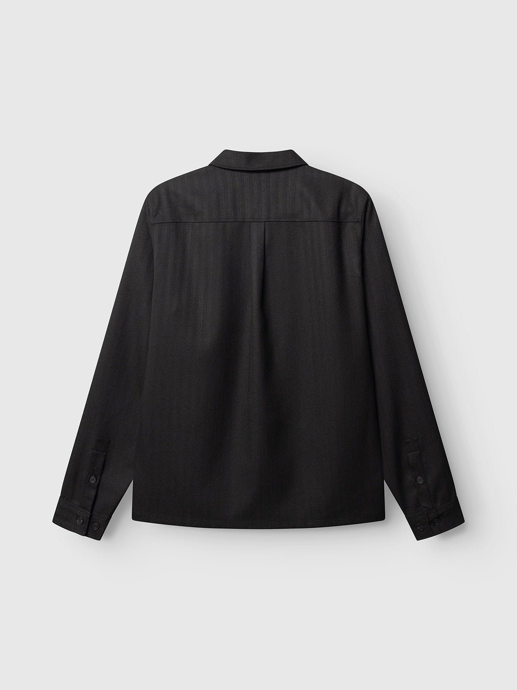 The GABfelix Fuyu LS Shirt - Meteorite by Gabba is a black long-sleeve shirt displayed from the back, featuring a classic collar and buttoned cuffs. Crafted from a soft viscose-blend fabric for enhanced comfort, its relaxed fit makes it perfect for everyday wear. The shirt is shown against a plain light gray background.