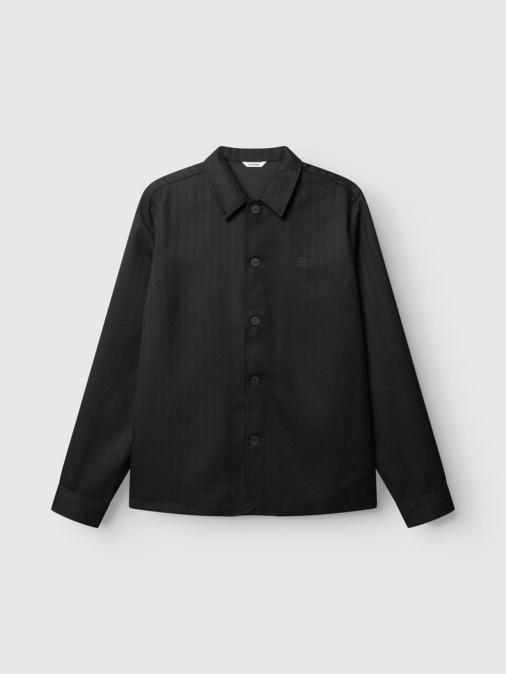 The Gabba GABfelix Fuyu LS Shirt in Meteorite is a black, long-sleeve button-up with a collar, displayed against a light gray background. Crafted from a soft viscose-blend fabric, it showcases a subtle stripe pattern and features a small embroidered logo on the left chest—ideal for everyday wear.