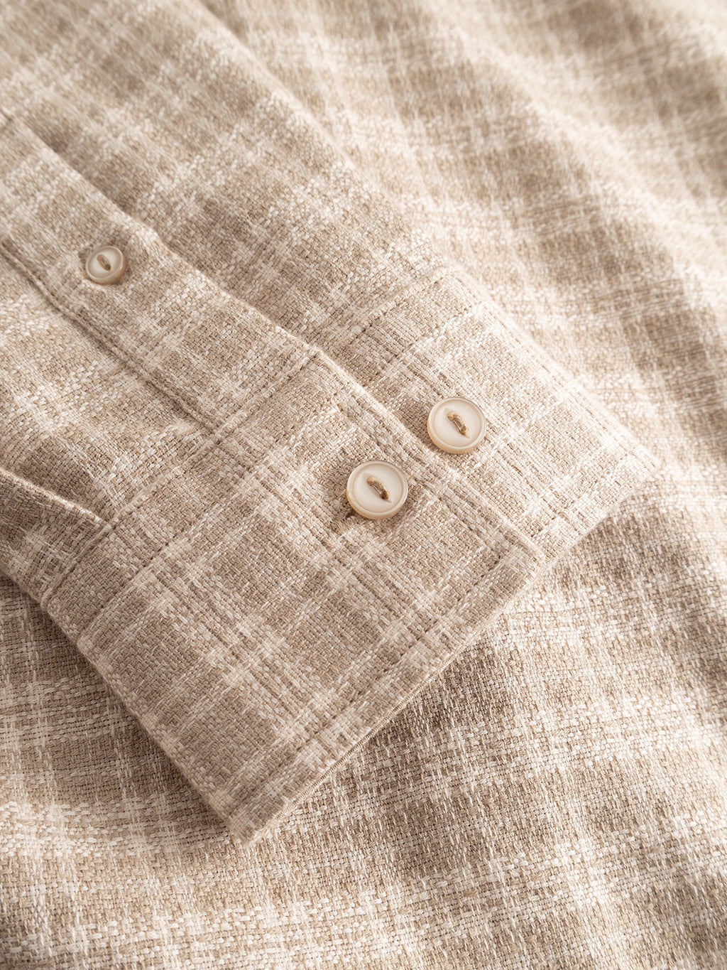 Close-up of the sleeve cuff of the Gabba GABsven Reg TX2 LS Shirt in Sand Crocker, featuring two cream-colored buttons and textured, yarn-dyed cotton fabric with a subtle plaid pattern.