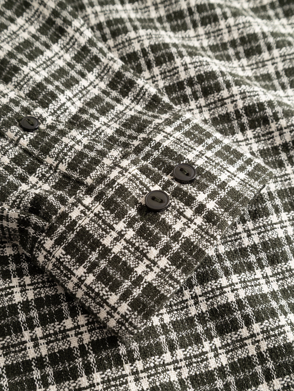 Close-up of the GABsven Reg TX2 LS Shirt - Forest Night by Gabba, featuring a black and white plaid yarn-dyed cotton sleeve with a checked texture and three black buttons on the cuff.