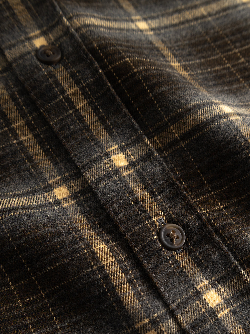 Close-up of the Gabba GABsven Reg F1097 LS Shirt in Forest Night, showcasing its brown and yellow checked plaid texture, two dark buttons, and detailed visible stitching.