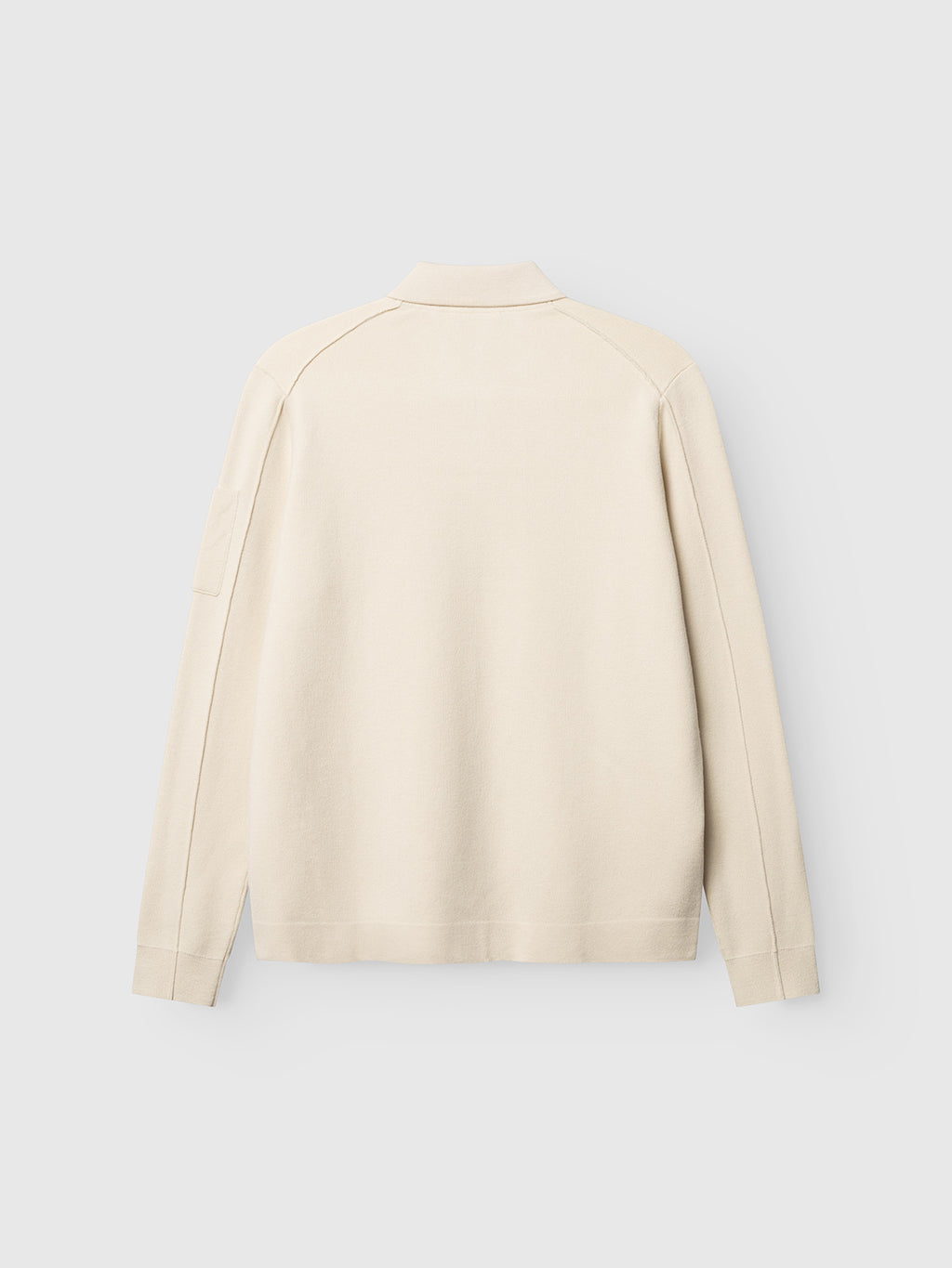 A back view of the Gabba GABadriel Zip Lume LS Knit in Birch, a cream-colored long-sleeve shirt featuring a collar and minimal seams, crafted from a soft viscose blend knit, is displayed against a plain light gray background.
